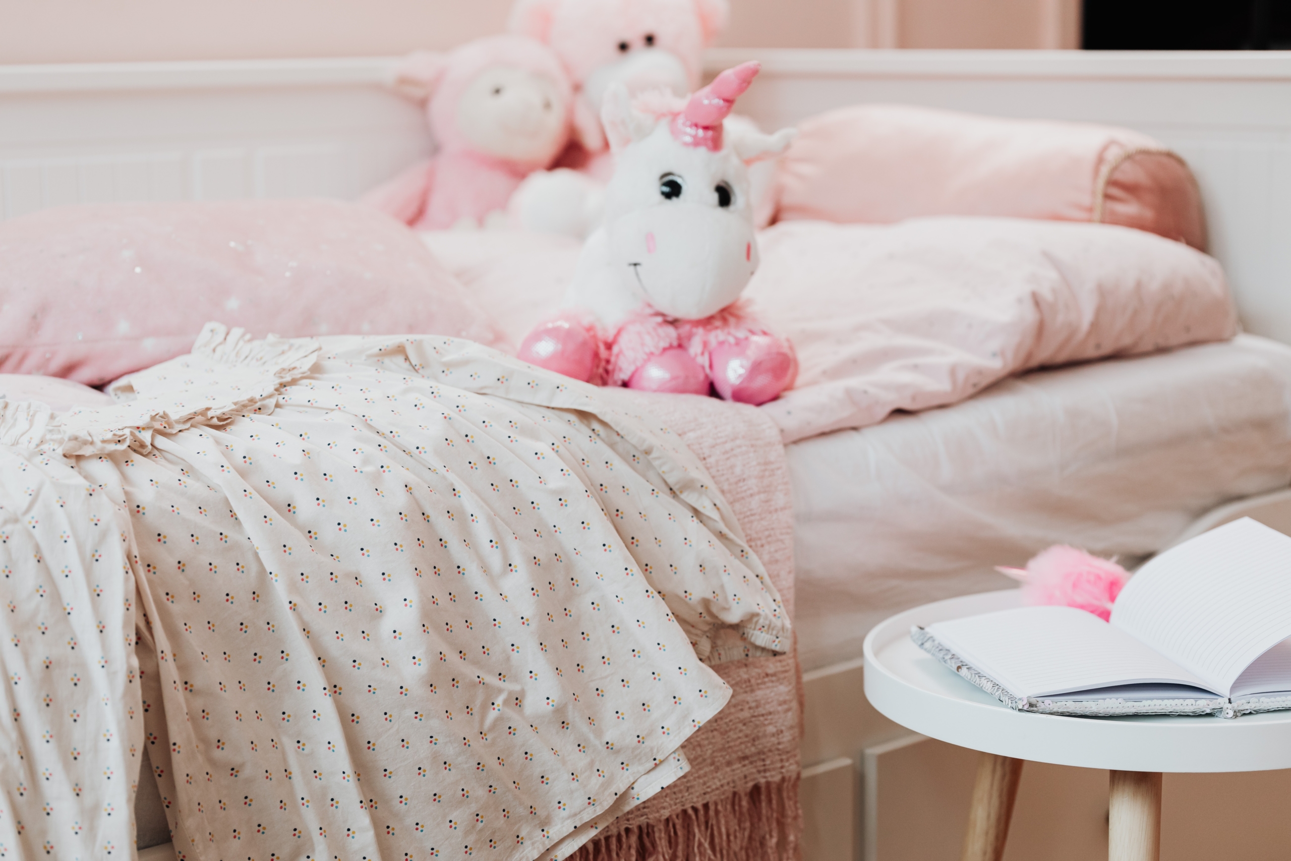 Plüscheinhorn auf einem rosa Kinderbett